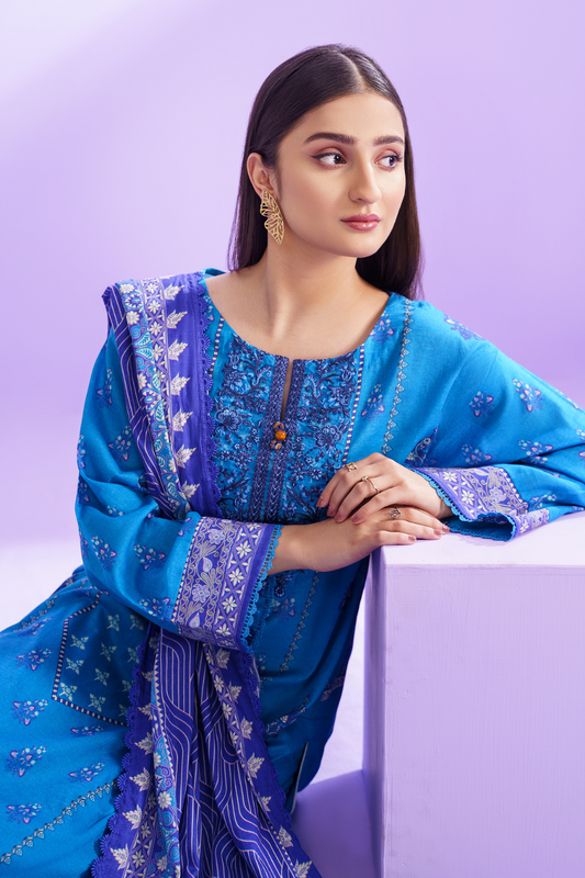 a young woman wearing an Ittehad blue embroidered suit and a blue embroidered dupatta.