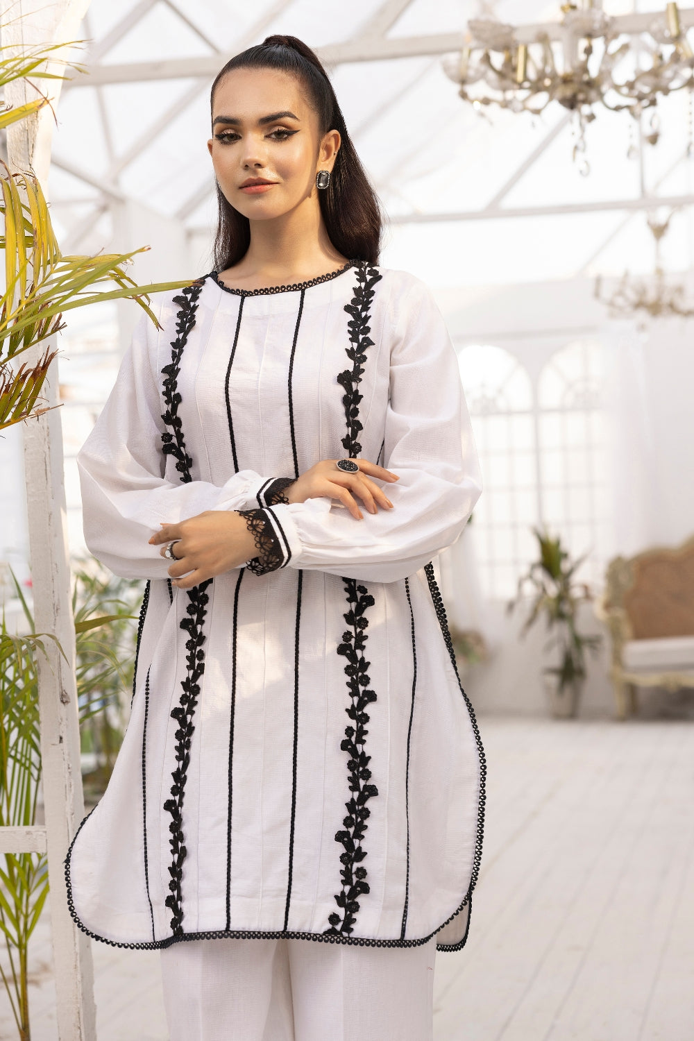 a girl is wearing 2 PC unstitched dobby shirt set with in white color with black design on it