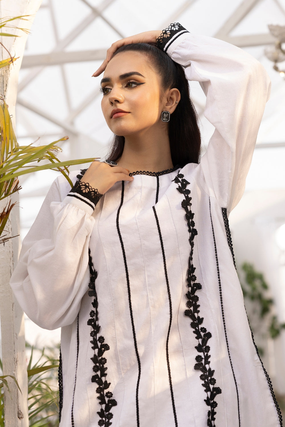 a girl is wearing 2 PC unstitched dobby shirt set with in white color with black design on it