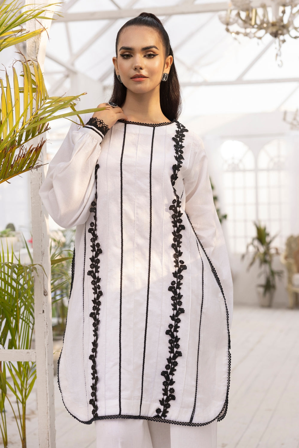 a girl is wearing 2 PC unstitched dobby shirt set with in white color with black design on it