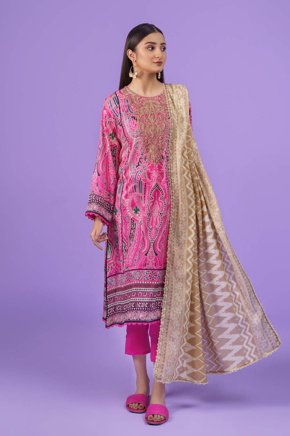 A woman wearing an Ittehad embroidered lawn suit and dupatta.