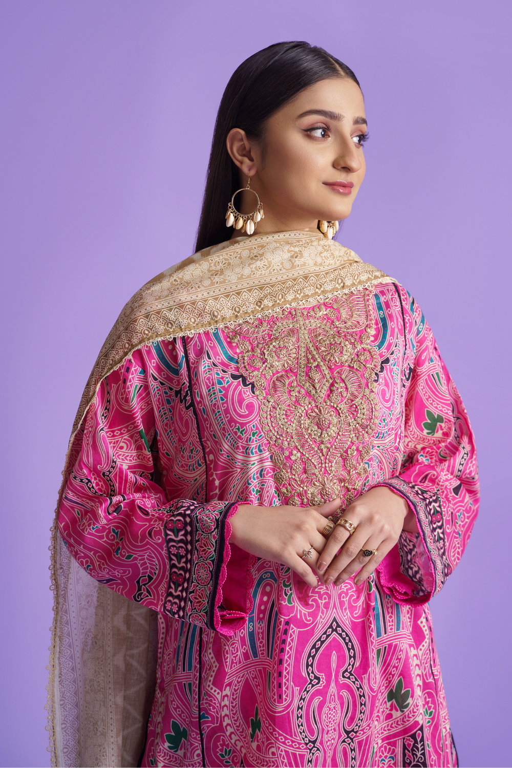 A woman wearing an Ittehad embroidered lawn suit.	